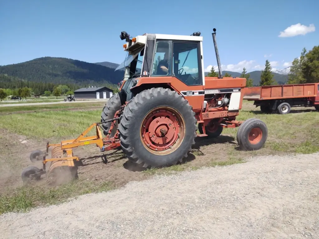 Our tractor spreading gravel on a new campground road in 2023