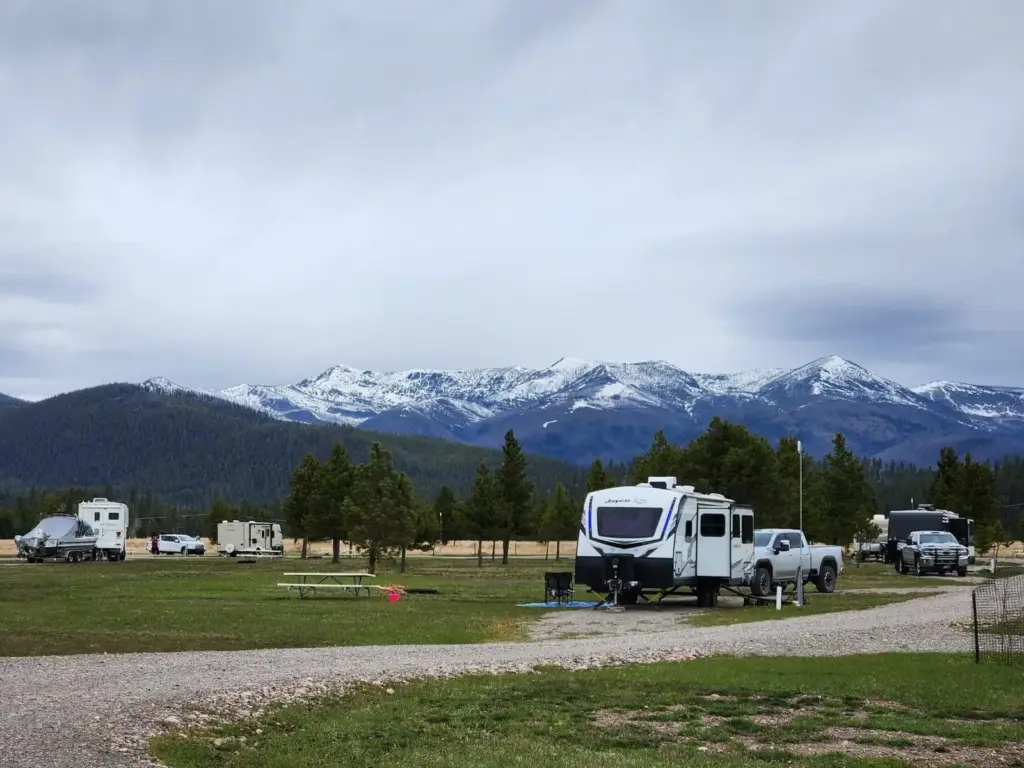 RVs on spacious sites below snowy peaks