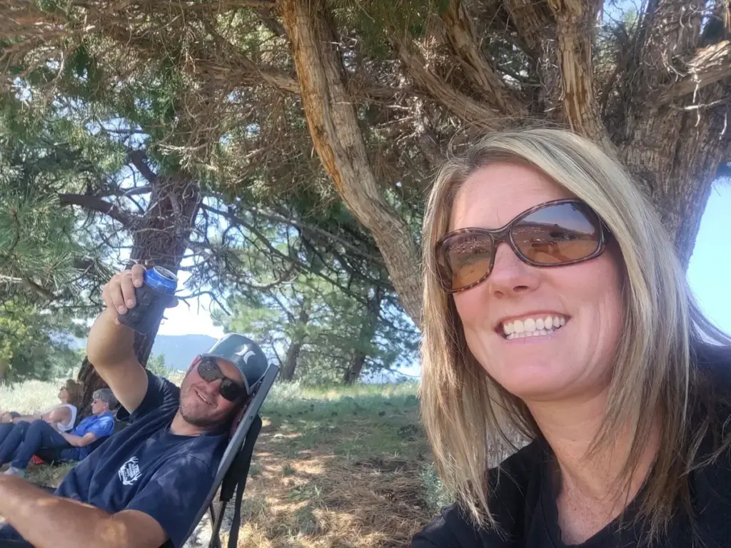 Matt and Nichole relaxing under a pine tree at camp in July 2021.