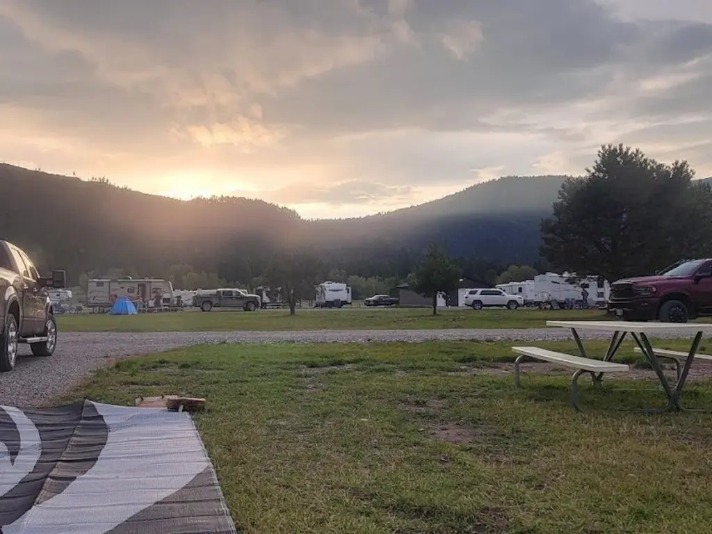 RVs on back-in sites around Loop A at sunset, with a pickup parked beside a travel trailer.